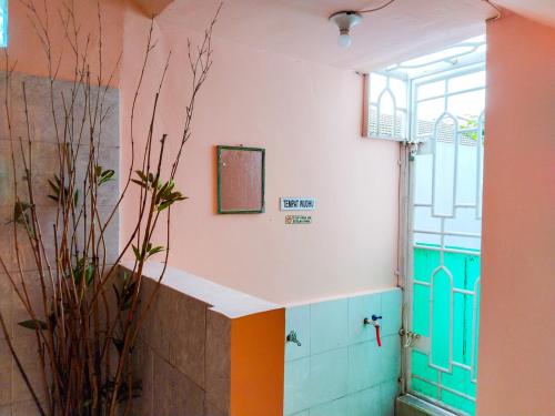 baño con paredes de colores y ventana en Grand Shaqilla Syariah, en Delitua