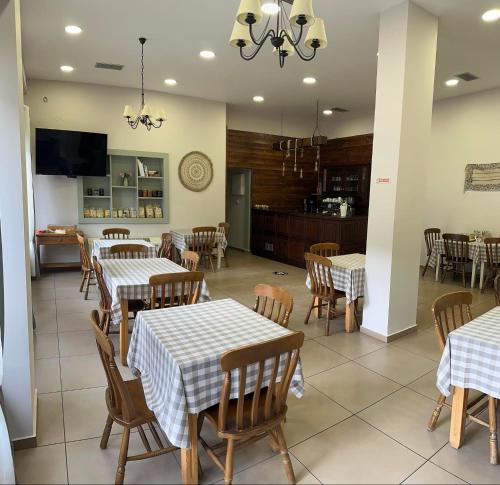 a restaurant with tables and chairs and a kitchen at Via Ferrata Hotel in Prousós