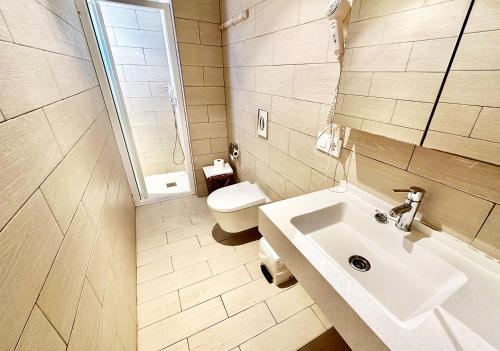 een badkamer met een wastafel en een toilet bij Hotel Marbel in Cala Ratjada