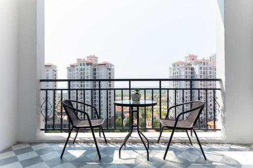 a balcony with a table and two chairs and a window at The Q Residence Vientiane in Vientiane
