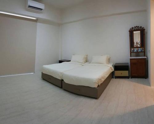 a bedroom with a large bed in a white room at By The Sea Deluxe Condo @ Batu Ferringhi Penang in Batu Ferringhi