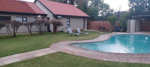un patio trasero con piscina y una casa en Hub Accomodation, en Kimberley