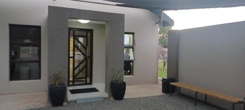 a room with two potted plants and a door to a building at Hub Accomodation in Kimberley