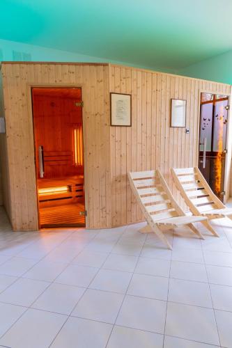 a room with wooden walls with two benches and a door at Aparthotel Bellamonte in Zakopane