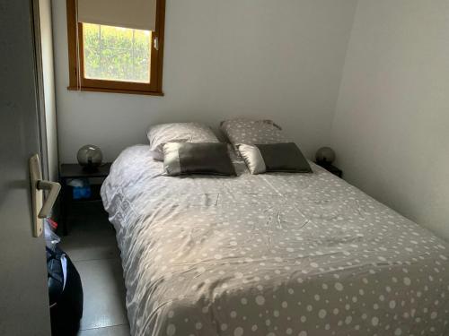 une chambre avec un lit avec deux oreillers dessus dans l'établissement La maison du bonheur 400 m de la plage de Richelieu, au Cap d'Agde