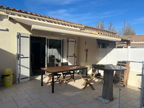 un patio avec une table et des chaises sur un patio dans l'établissement La maison du bonheur 400 m de la plage de Richelieu, au Cap d'Agde