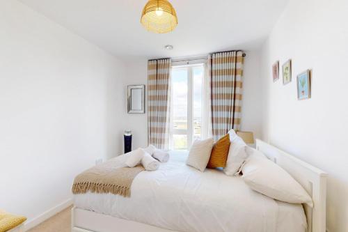 a bedroom with a white bed with a window at 2Bed Apartment with Lift and Balcony - 2min to Station in London
