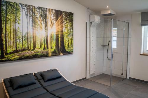 een badkamer met een schilderij van bomen aan de muur bij Ferienwohnung mit Sauna „Eschblick“ in Versmold