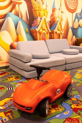 an orange toy car in front of a couch at Aparthotel Bellamonte in Zakopane