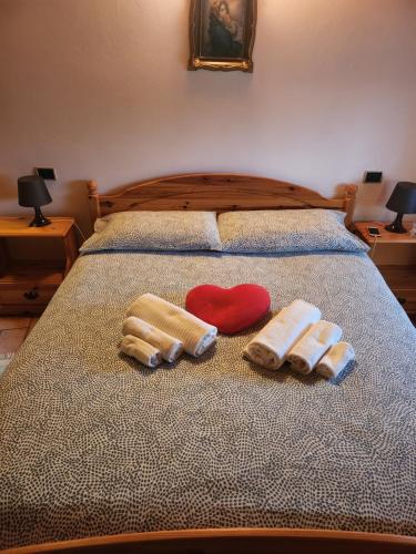 a bed with two pairs of mittens and a red heart at Mansarda Dolomitica in Ronzo Chienis