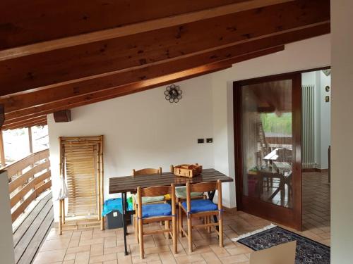 a dining room with a wooden table and chairs at Mansarda Dolomitica in Ronzo Chienis