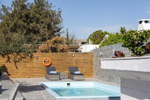 a patio with two chairs and a swimming pool at Villa Perla in Lardos