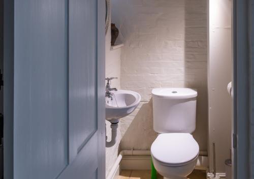 a bathroom with a toilet and a sink at The Triumphal Arch West in Holkham