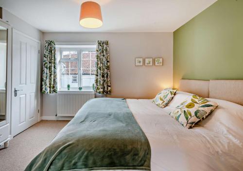 a bedroom with a large bed and a window at Quay View Cottage in Wells next the Sea