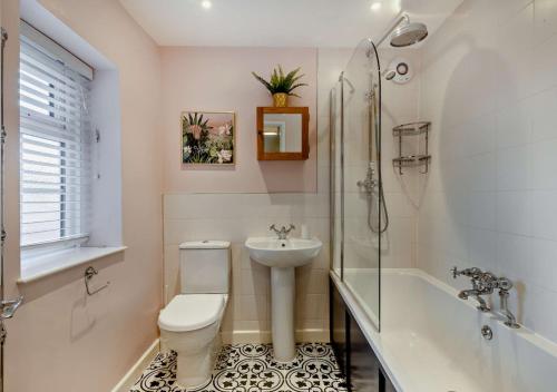 a bathroom with a toilet and a sink and a tub at Quay View Cottage in Wells next the Sea