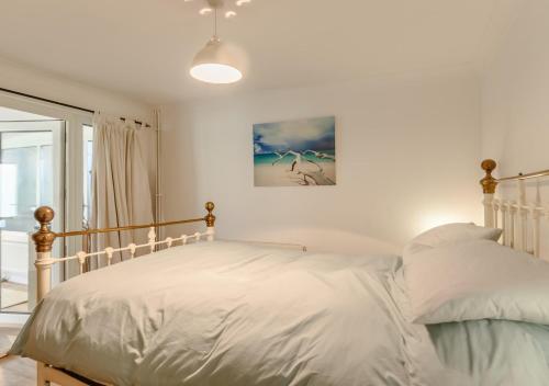 a bedroom with a white bed and a picture on the wall at The Annexe at Hideaway Cottage in Ellingham