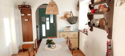 a dining room with a table and a green door at Villa Carla - Istrian house in Koper
