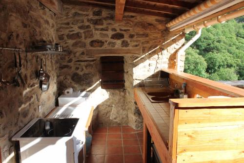 - une cuisine avec une cuisinière et un évier dans un bâtiment dans l'établissement MOULIN DELEUZE Chambre Le Chalet avec terrasse, à Beaumont