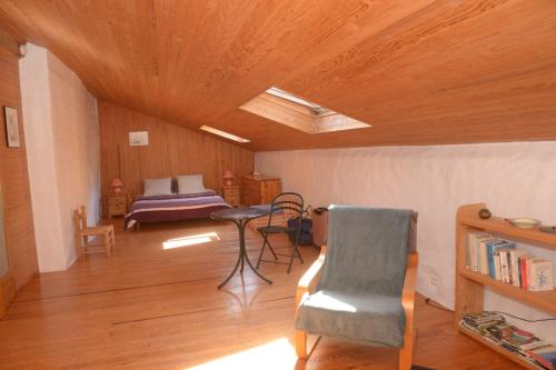 une chambre avec un lit, une table et une chaise dans l'établissement MOULIN DELEUZE Chambre Le Chalet avec terrasse, à Beaumont