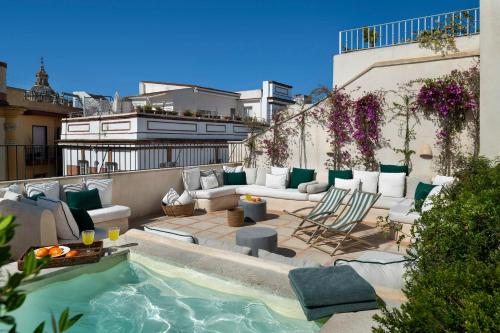 a rooftop patio with a pool and furniture on a building at Casa del Rey Sabio in Seville