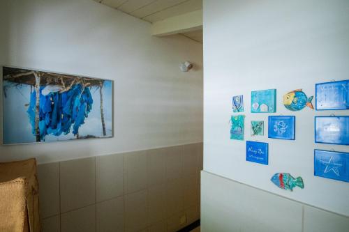 a room with blue pictures on the wall at MADIROKELY HOUSE Nosy Be in Ambatoloaka