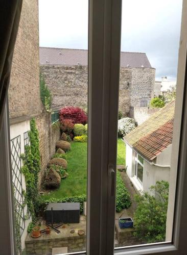 Elle offre une vue sur le jardin depuis sa fenêtre. dans l'établissement Porte Neuve - Remparts Boulogne, à Boulogne-sur-Mer
