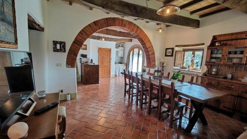 una grande cucina con tavolo e sedie lunghi di Casale Alcinoo - Rustico a Tuoro sul Trasimeno