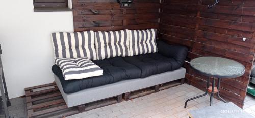 a black couch with a blanket on a wall at Kaszuby Punkt Klonowo Przywidz sauna klima basen in Przywidz