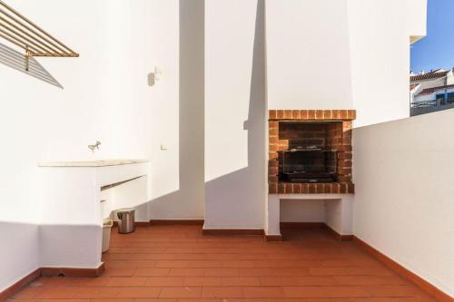 un soggiorno con camino in una stanza bianca di Odeceixe Valley Tranquility a Odeceixe
