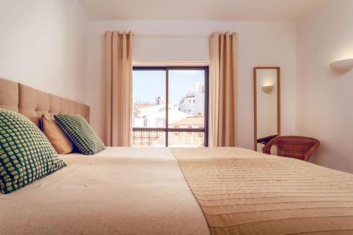 una camera da letto con un letto grande con una grande finestra di Odeceixe Valley Tranquility a Odeceixe