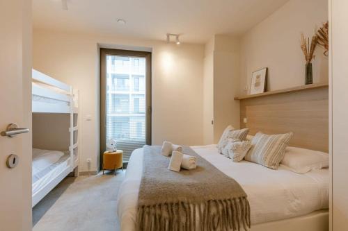 - une chambre avec un grand lit blanc et une fenêtre dans l'établissement Lovely new apartment close to the sea, à Ostende