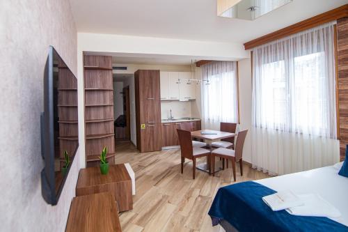 a bedroom with a bed and a table and a kitchen at Central Inn in Zlatibor