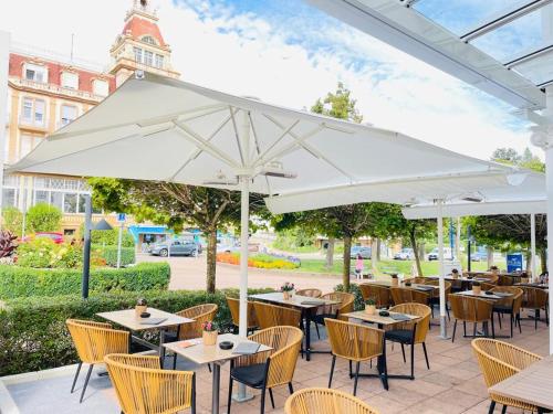 バート・ヴィルドゥンゲンにあるGöbel`s Hotel Quellenhofのパティオ(テーブル、椅子、白い傘付)