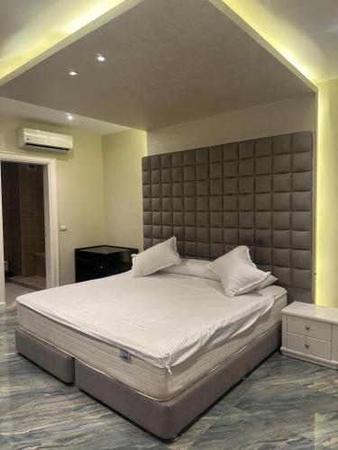 um quarto com uma cama grande e uma grande cabeceira. em Dreamland villa em ‘Ezbet `Abd el-Ḥamîd
