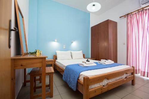 a bedroom with a bed and a table and a desk at Kalami Apartments in Falasarna