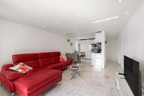 ein Wohnzimmer mit einem roten Sofa und einer Küche in der Unterkunft Red View Apartment - Happy Rentals in Ronco sopra Ascona