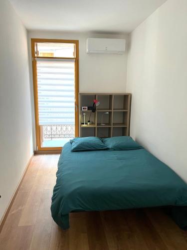 une chambre avec un grand lit et une fenêtre dans l'établissement Charmant appartement en centre-ville, à Sète