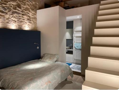 a bedroom with a bed next to a staircase at Chambre B&B dans appartement vue Saône calme absolu in Lyon