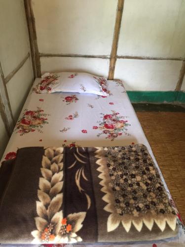 a bed with two blankets and two mats on it at Mount fuji homestay in Deorāli