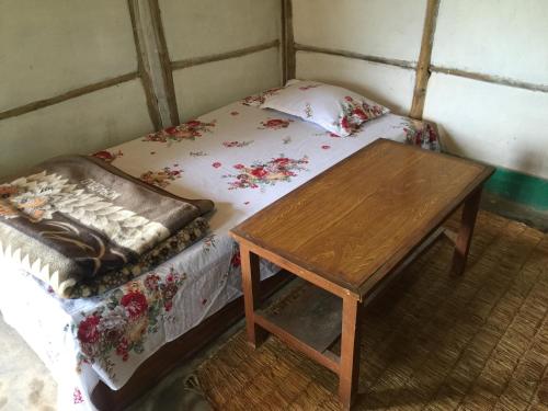 a small room with a bed and a wooden table at Mount fuji homestay in Deorāli