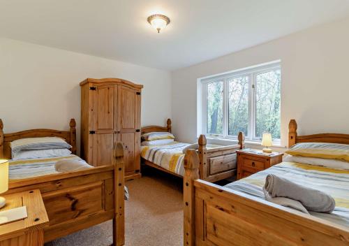 a bedroom with two beds and a window at Waters Edge in Pentney