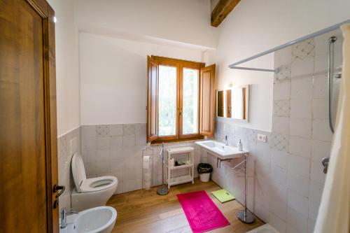 baño con aseo y lavabo y ventana en Agriturismo Bio San Mamiliano en Grosseto