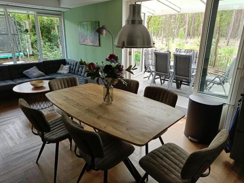 a living room with a wooden table and chairs at Bosvilla Lochem in Lochem
