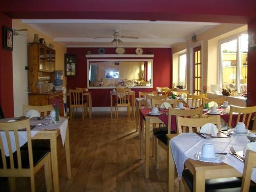 restauracja ze stołami i krzesłami w pokoju w obiekcie Arkale Lodge w mieście Carlisle