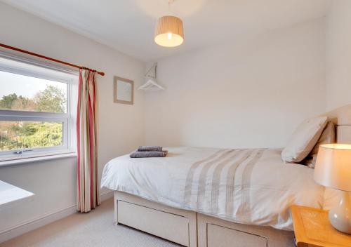a white bedroom with a bed and a window at Woodcocks in Docking