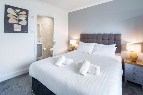 a bedroom with a large white bed with towels on it at Gwbert Holiday Cottages, Gwynt Y Mor in Cardigan