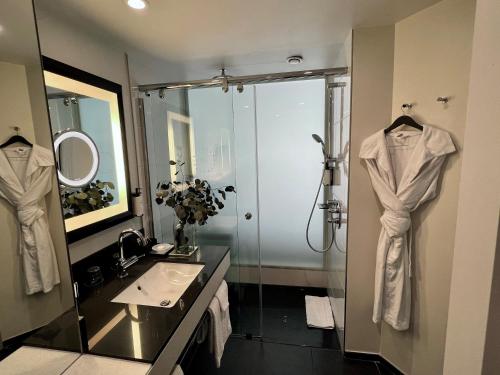 a bathroom with a shower and a sink and a mirror at Sofitel Brussels Europe in Brussels