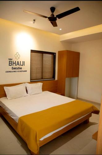 a bedroom with a large bed with a ceiling fan at Hotel Bhaiji Executive in Nānded