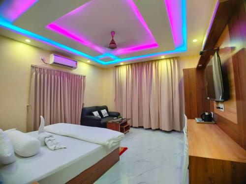 a hotel room with a bed and a tv at The Triton Beach Resort in Mandarmoni