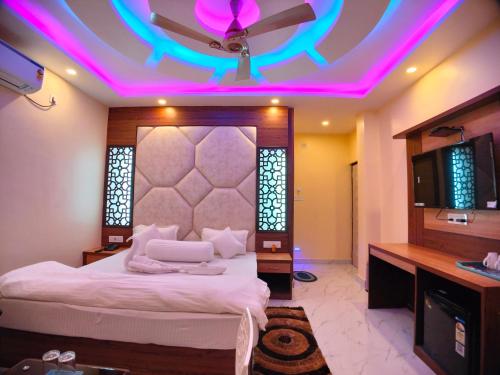 a bedroom with a bed with a purple lighting at The Triton Beach Resort in Mandarmoni